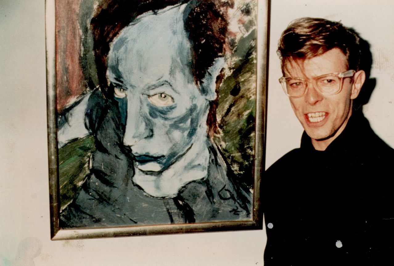 somedevil:

David Bowie with his 1976 painting of Iggy Pop, Portrait of J.O. 
