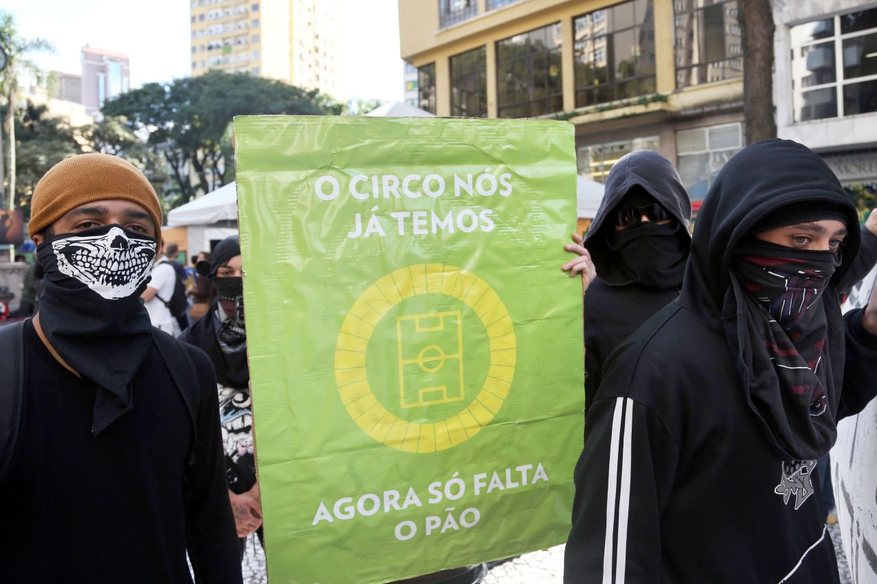 CIRCO. Manifestantes contra la FIFA bloquean una calle cerca del estadio da Baixada en Curitiba, Brasil el 16 de junio de 2014, mientras se juega el partido entre Irán y Nigeria.  El cartel dice &#8220;El circo ya lo tenemos, ahora solo falta el pan&#8221;. (AFP  / ORLANDO KISSNER)