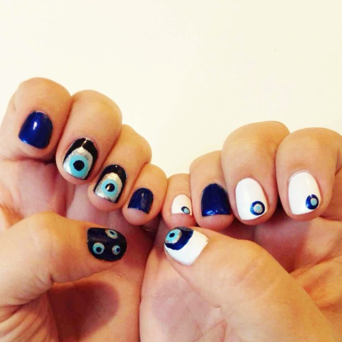 Evil Eye Nail Art DIYCOLORSNARS Pierre Hardy - Ethno Run, Navy Sally Hansen Xtremewear - Celeb City (220)Julep - BessEssie - Aruba BlueMaybelline - Porcelain PartyHOW-TO1. Paint base solid color, allow to dry.2. Dab silver polish for the eyeball on to the flat, blunt side of a cheap ballpoint pen, lightly press wet polish onto nail like a stamp. Allow to dry. 3. Dip the ballpoint pen (writing side) or a dotting tool into light blue polish for the eye color and then let it dribble onto the middle point of the eyeball. Use the tool to expand the eye color, if necessary. Allow to slightly dry, wipe polish off tool.4. Place a small amount of dark blue polish into the tip of the ballpoint pen or dotting tool and precisely draw the pupil on to the evil eye. Allow to dry completely. 