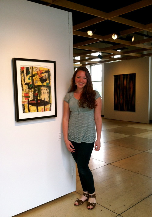 Photo of the 2013 Judy Cheteyan Scholar standing in front of a fiber piece in Contemporary Craft's gallery