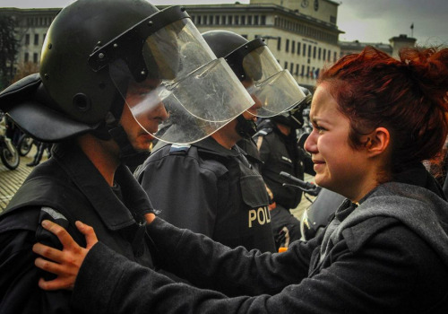 deathtofuckingdestiny: supalove: thinksquad: This girl was crying and begging the policeman not to hit her or any of her friends. Then the policeman started crying as well and he said to her: “You just hold on girl.” The photo comes from protests happening in Bulgaria right now. Students are protesting poverty and corruption in Bulgaria’s Socialist-backed government, chaining themselves to the doors of Sofia University and clashing with police outside of parliament. After the photo was taken it quickly went viral this picture is so powerful You can actually see that he is about to start crying in his lips. 