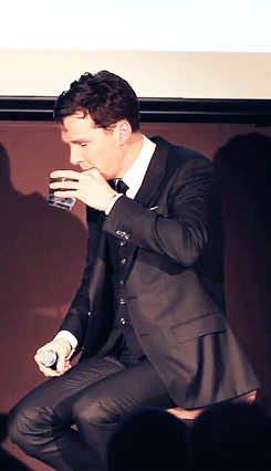 a man with a microphone is drinking a beverage.